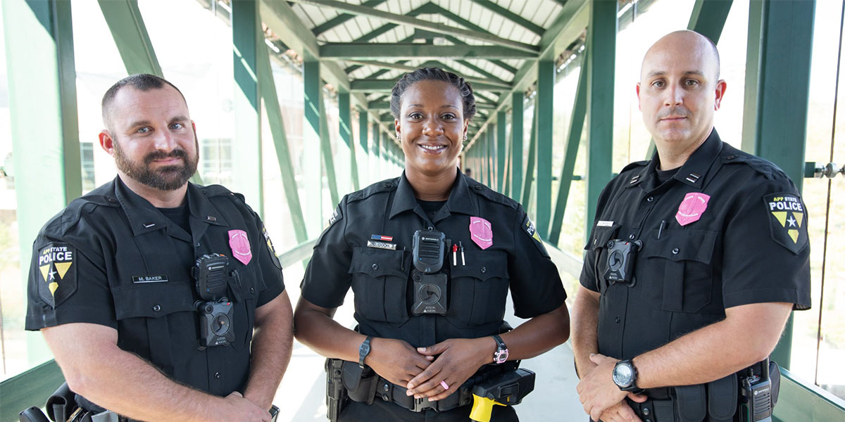 Three officers wearing pink awaneress badges