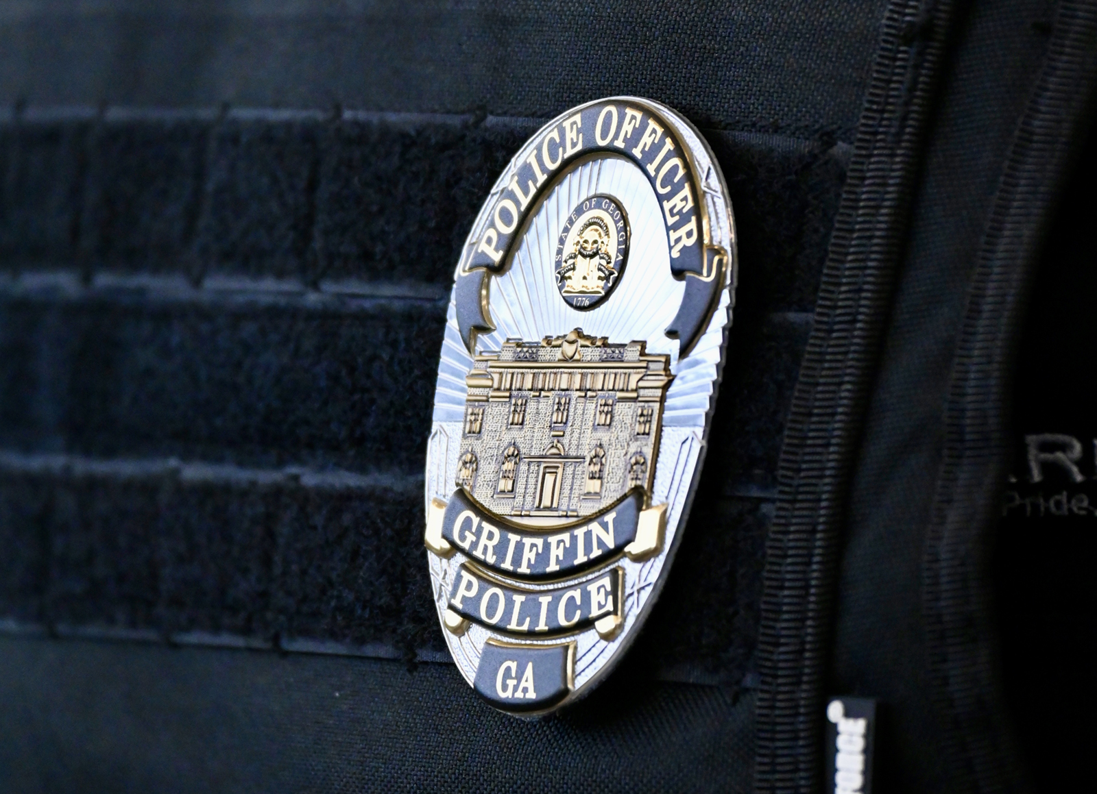 Flexible badge on police officer outer vest carrier