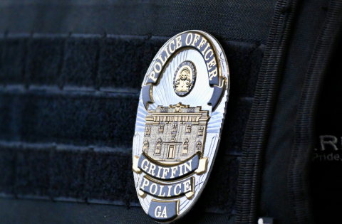 Flexible badge on police officer outer vest carrier